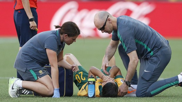 Sam Kerr receives treatement on the pitch.