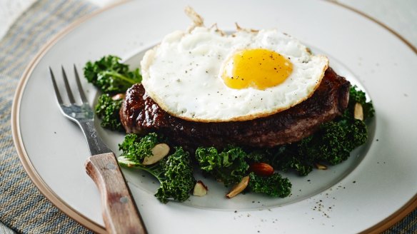Paleo steak with sauteed kale and fried egg cooked using coconut oil 