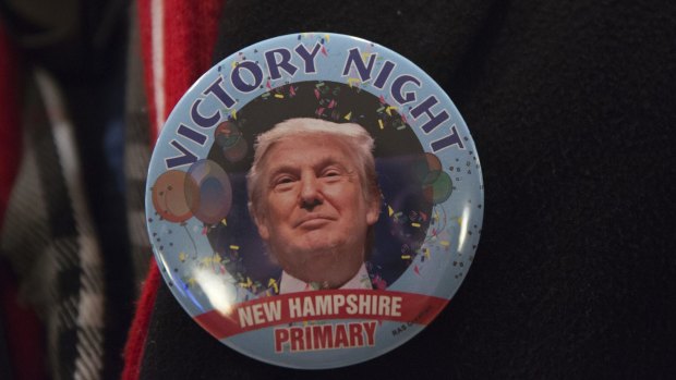An attendee wears a victory campaign button for Donald Trump during a primary watch party in Manchester, New Hampshire.