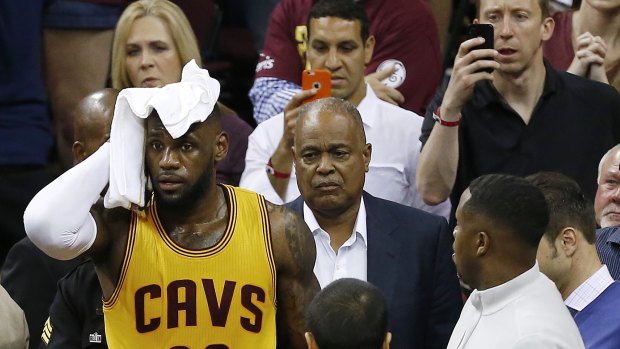 LeBron James holds a towel to his head after he collided with a TV cameraman during the first half of Game 4.