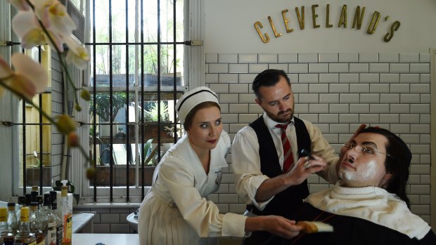 Brother and sister Jane Ede (left) playing Berta and David Parkin (right) playing Don Basilio in The Barber of Seville being sheved by Barber Patrick Casey (centre) at Cleveland's barber, Redfern. 