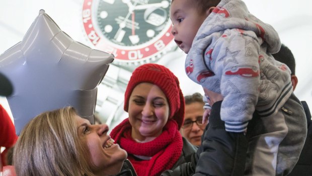 Tima Kurdi, left, who lives in the Vancouver area, lifts her five-month-old nephew, Sherwan Kurdi, after her brother, Mohammad Kurdi, and his family, arrive in Canada as refugees.