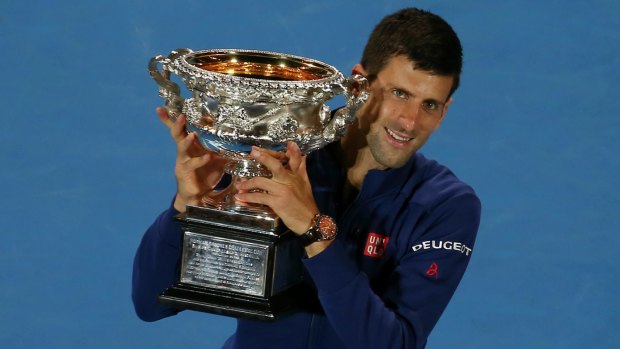 Six of the best: Novak Djokovic celebrates victory with the Australian Open trophy.
