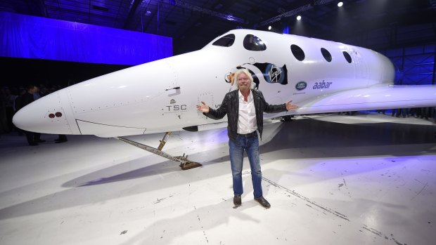 Sir Richard Branson poses in front of Virgin Galactic's SpaceShipTwo space tourism rocket after it was unveiled.