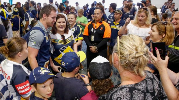 Tropical hero: Michael Morgan is swamped by supporters after the Cowboys arrive at Townsville Airport.