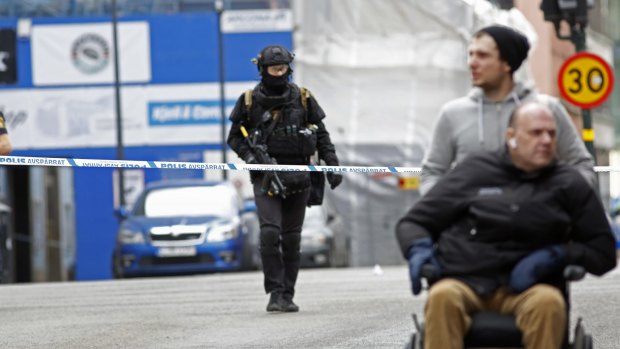 Armed Swedish police officers close off a city street after a hijacked truck slammed into a building in downtown Stockholm.