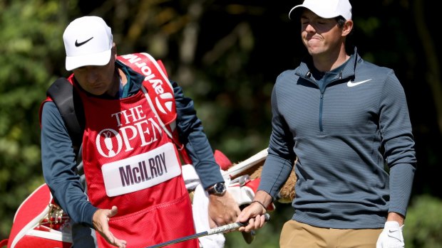 Rory McIlroy of Northern Ireland looks dejected as he hands the club to his caddie JP Fitzgerald.