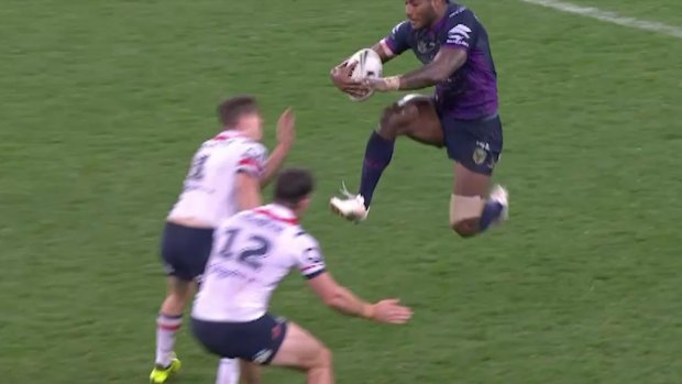 Melbourne's Suliasi Vunivalu leaps with his knees at the Roosters defenders.
