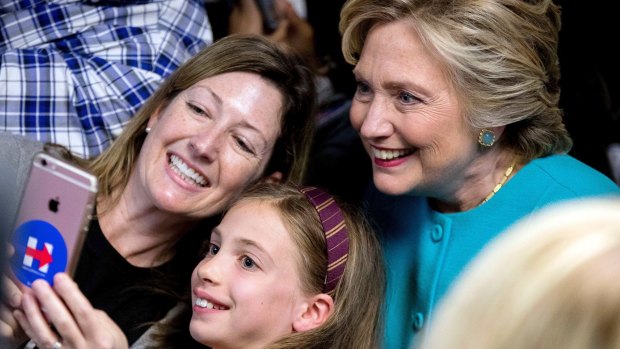 Feeling emboldened: Hillary Clinton gets a selfie with supporters.