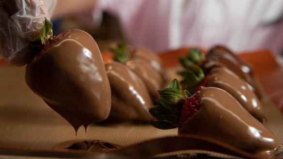 Rodrigo Schneider dips strawberries in chocolate in the David Jones Food Hall.