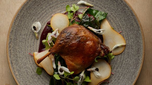 Confit duck leg with pears and broad bean flowers.