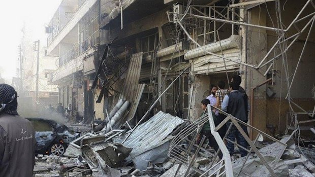 People gather at the site of an air strike in Al-Bab on the outskirts of Aleppo, Syria. 