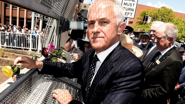 Prime Minister Malcolm Turnbull throws the first rose at Granville. 