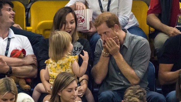 Prince Harry sits with spectators during the sitting volleyball competition at the Invictus Games in Toronto on Wednesday, Sept. 27, 2017. 