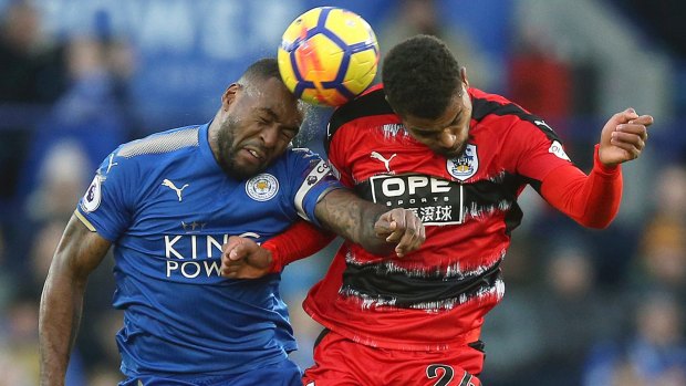 Leicester City's Wes Morgan, and Huddersfield Town's Steve Mounie clash at the King Power Stadium.