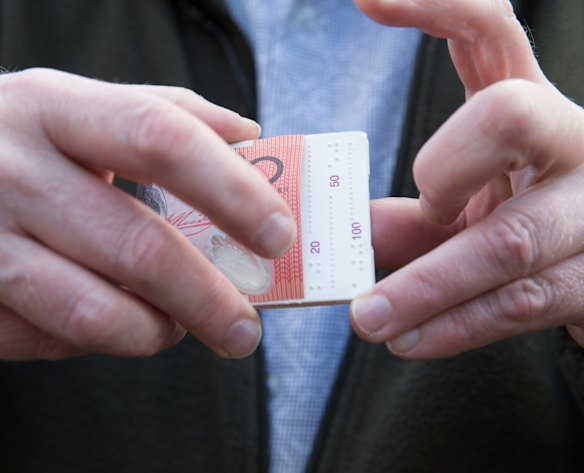 Bruce Maguire, policy adviser at Vision Australia, demonstrates a device he uses for measuring bank notes.