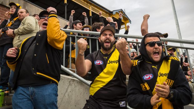 RIchmond fans cheer on their side at Punt Road Oval, as thousands of Tiger fans watch the Grand Final. 