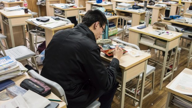 A student eats his lunch while sitting in his classroom at Shanghai High School in Shanghai, China. 