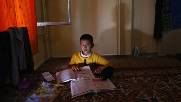 An Uighur refugee boy does his homework  in a gated complex in the central city of Kayseri, Turkey.