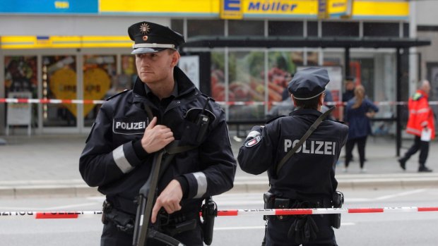 Police officers secure the area after the knife attack at a supermarket in Hamburg.