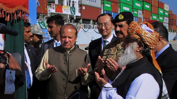 Pakistan's Prime Minister Nawaz Sharif, centre left, and Army Chief General Raheel Sharif, third from right, pray after inaugurating a new international trade route during a ceremony at Gwadar port.