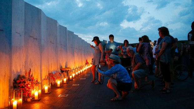 Candles in memory of the passengers and crew of Flight 93, are lit along the Wall of Names at the Flight 93 National Memorial in Shanksville, Pennsylvania.