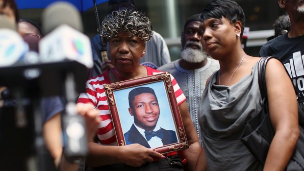 July 2015: Gwen Carr, mother of Eric Garner, who died after a police officer used a choke hold on him in 2014, holds a photo of him at a news conference in New York. 