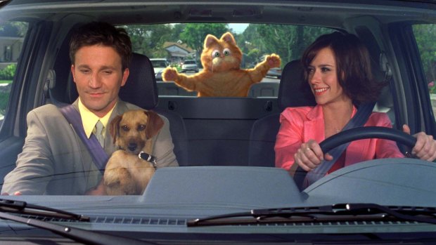 Garfield, center (voiced by Bill Murray), competes with a dog named Odie, for the affection and attention of their human master, Jon (Breckin Meyer), and Liz (Jennifer Love Hewitt), Garfield's veterinarian in "Garfield!"