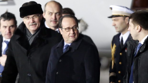 French President Francois Hollande stands beside a Russian official after arriving in Moscow.
