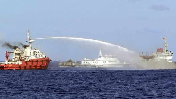 A Chinese ship sprays water on a Vietnamese vessel, right, while a Chinese Coast Guard ship, centre, sails alongside in the South China Sea in May 2014. 