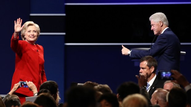 Hillary Clinton, 2016 Democratic presidential nominee, left, waves as former US president Bill Clinton gestures during the first US presidential debate.