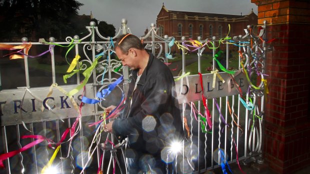 Former St Patrick's College student Peter Blenkiron at St Patrick's College in Ballarat with ribbons which have been attached to the front gate.