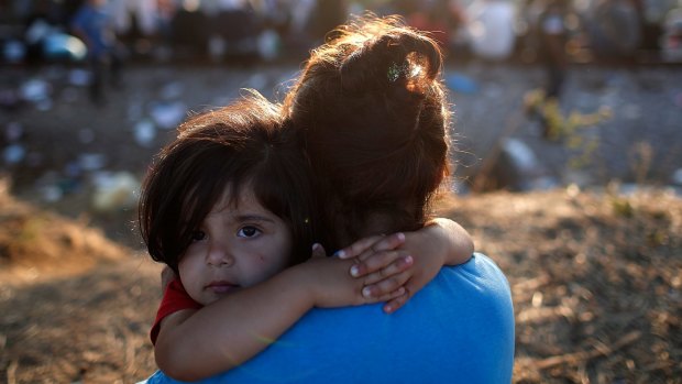 A young Syrian girl and her mother next to railroad tracks in Greece where migrants wait to cross into Macedonia. 