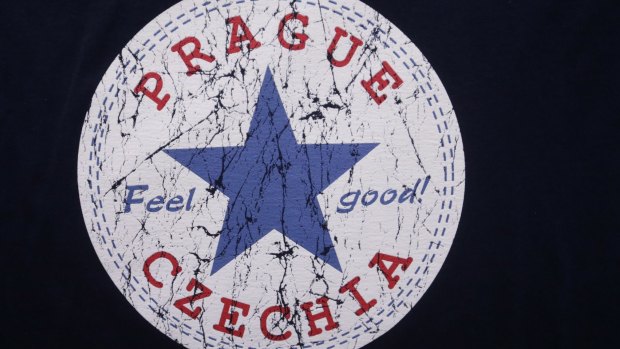 A sign with the word "Czechia" is printed on a T-shirt displayed in a store in Prague.