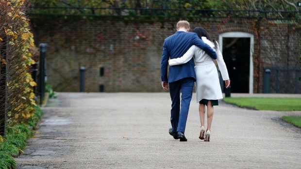 Britain's Prince Harry and Meghan Markle walk away after posing for photos following their engagement announcement. 