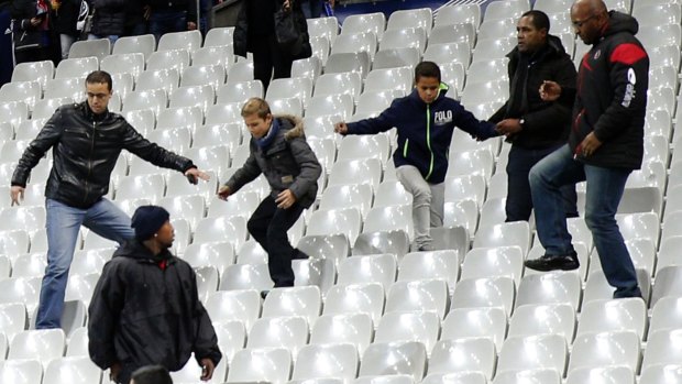 Soccer fans leave the Stade de France stadium after an international friendly soccer match in Saint Denis, outside Paris. An explosion occurred outside the stadium. Several dozen people were killed in a series of unprecedented attacks around Paris on Friday, French President Francois Hollande said, announcing that he was closing the country's borders and declaring a state of emergency.
