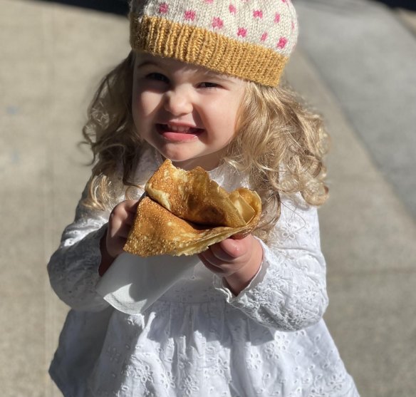 A young customer enjoys a free crepe from Le Coq.