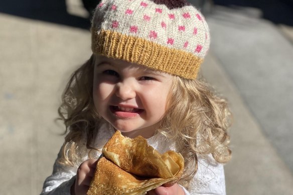 A young customer enjoys a free crepe from Le Coq.