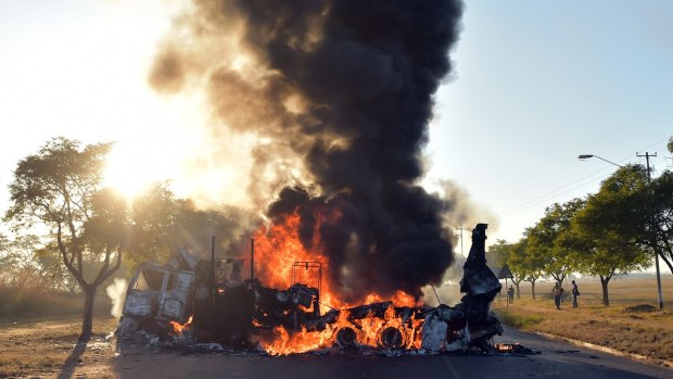 A vehicle burns on a road outside Pretoria.