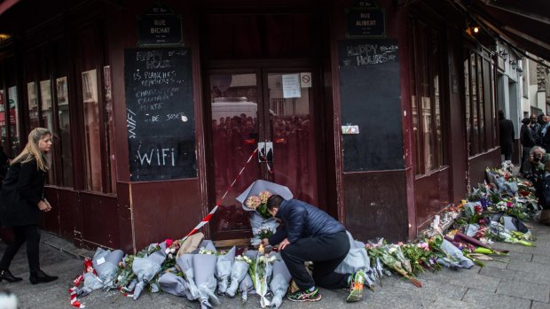 A man leaves floral tributes outside Le Carillon restaurant.