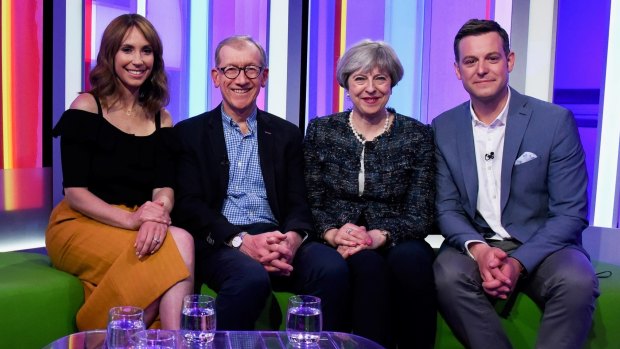 British Prime Minister Theresa May, second right, and her husband Philip May, second left, pose with presenters Alex Jones and Matt Baker as they appear on BBC's The One Show.