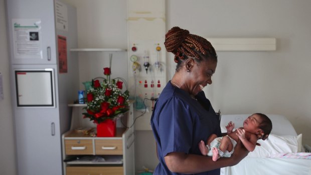 A registered midwife with newborn Jewel, daughter of Rasadari Kekulthotuwage Dona and father Asin Silva at the Blacktown Hospital maternity ward.
