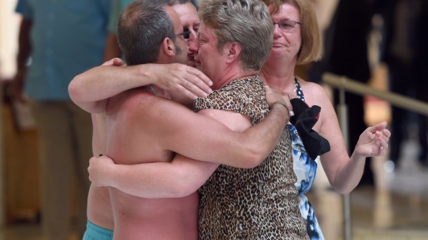 Tourists console each other following the shooting attack.