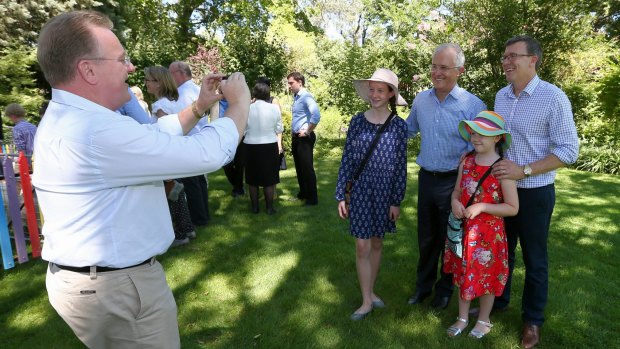 Liberal MP Bruce Billson helps Alan Tudge take of photo of his family together with Prime Minister Malcolm Turnbull.