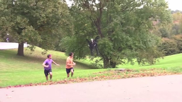 Grim message: Joggers run away from a drone involved in a Halloween prank posted on YouTube.
