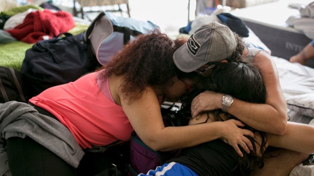 A family hugs upon their arrival at a shelter at St Thomas Presbyterian Church in west Houston after Harvey.