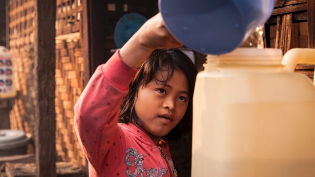 Htoi Nu Mai, 9, fills up a water container outside her family's shelter at the Phan Khar Kone IDP camp in Bhamo city, Kachin State, Myanmar.
