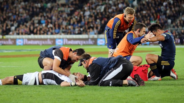 Down and out: Willie Le Roux of the Sharks and Jason Emery of the Highlanders are treated after a nasty collision.