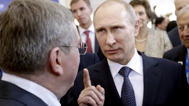 Russian President Vladimir Putin talks with International Olympic Committee President Thomas Bach.