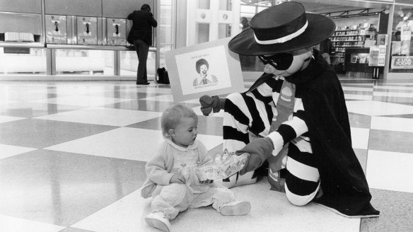 The Hamburglar hands a Happy Meal to one-year-old Cameron Rose Conlon in the United Airlines terminal at O'Hare International Airport in the US in 1991.